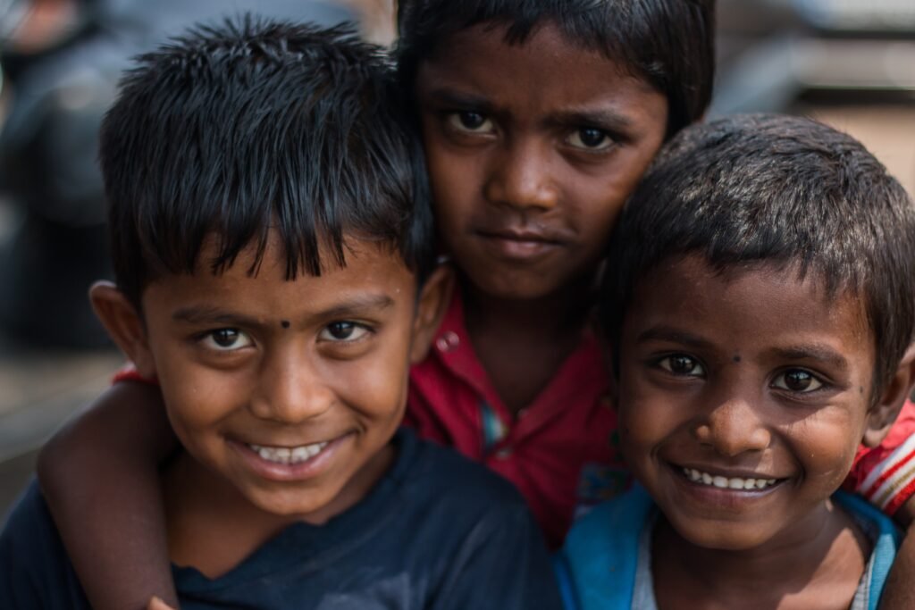 Three smiling children supported by the work of the SHCH Foundation.